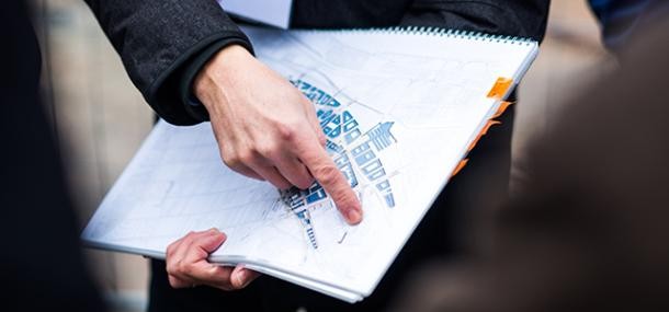 Fragen zum Thema Wohnen und Bauen beantwortet das Technische Bürgeramt (Foto: Dittmer) Mensch mit Bebauungsplan in der Hand