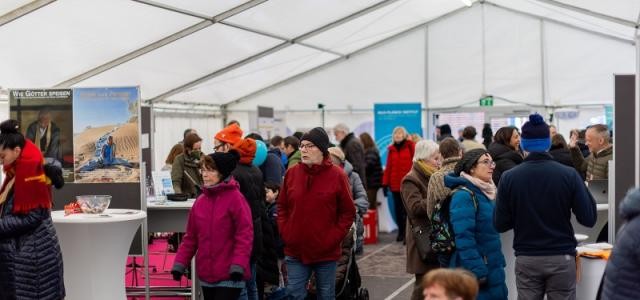 Menschen laufen durch ein großes weißes Zelt.