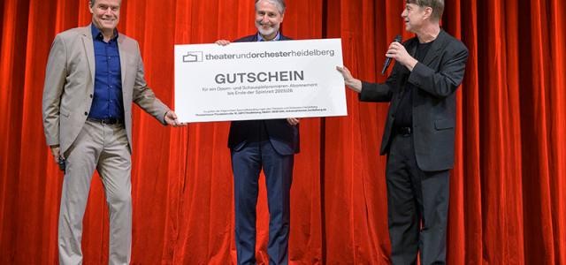 Oberbürgermeister Würzner und Theater-Intendant Schultze überreichen Gerner einen riesigen Gutschein für ein Premierenabo des Theaters.