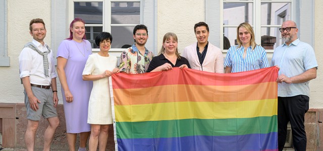 Menschen zeigen eine bunte Flagge