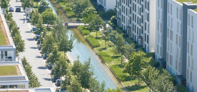 Luftaufnahme eines angelegten Wasserbeckens umgeben von viel Grün.