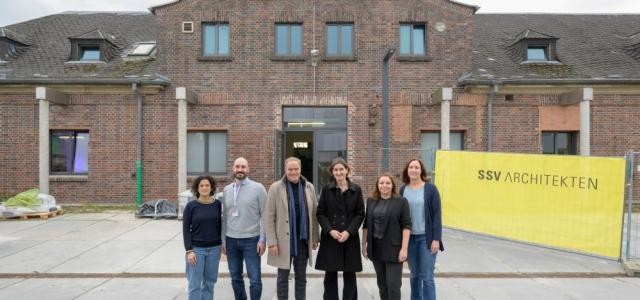 Sechs Menschen vor Ziegelsteingebäude
