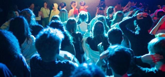 Eine Gruppe tanzender Kinder in einem mit Discolichtern beleuchteten Raum