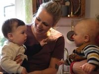 Zwei Babys lächeln sich an. (Foto: Kevin Bohla) Ein Baby auf dem Arm einer Frau lächelt ein gleichaltriges Baby an.