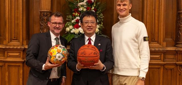 Heidelberg und Kumamoto planen regelmäßige Austausche im Jugendsport, beginnend vor allem im Fußball und Basketball. Kumamotos Oberbürgermeister Kazufumi Onishi (Mitte) überreichte Bürgermeister Raoul Schmidt-Lamontain (links) symbolisch einen verzierten Fußball. Im Gegenzug schenkte Niklas Würzner, Spieler des Basketball-Bundesligisten MLP Academics Heidelberg, den Gästen aus Kumamoto einen von den Spielern unterschriebenen Basketball. (Foto: Tobias Dittmer)