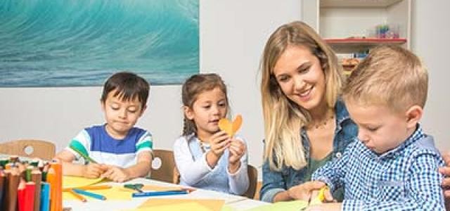 Foto von Frau und drei Kindern beim Malen