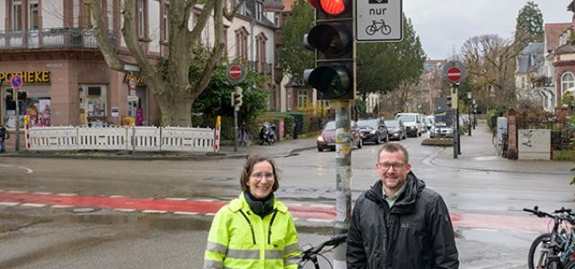Zwei Menschen stehen vor einer Ampel.