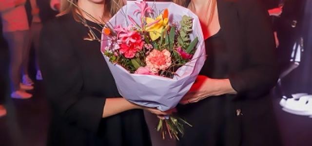 Geschäftsführerin Esther Schenkel-Aslantas bekommt einen Blumenstrauß überreicht.