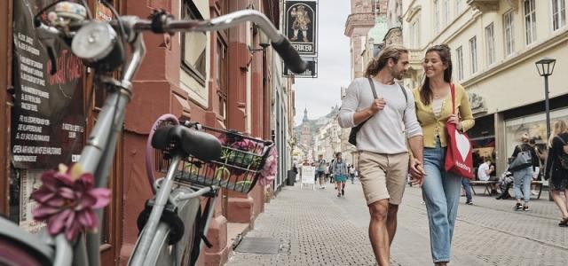 Ein Pärchen geht in der Hauptstraße auf Shopping-Tour.
