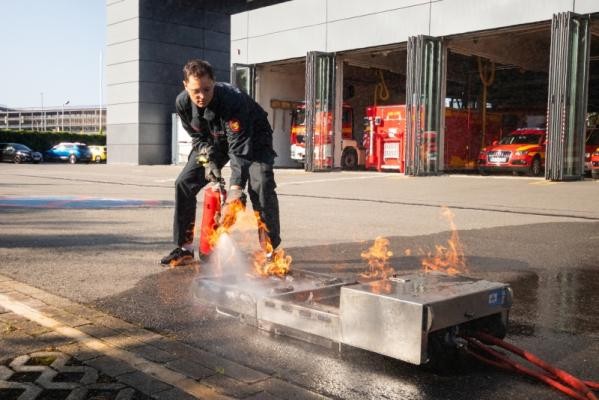Praktischer Umgang mit Feuerlöschern Feuerwehrmann löscht ein Feuer mit einem Feuerlöscher