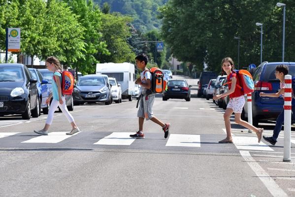 Auch in Heidelberg beteiligen sich Grundschulen im Oktober wieder am Zu-Fuß-zur-Schule-Monat. (Foto: Dorn) Drei Kinder mit Schulranzen laufen über einen Zebrastreifen.