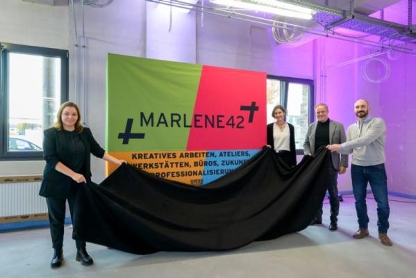 Das neue Kultur- und Kreativwirtschaftszentrum in der Südstadt wird MARLENE 42 heißen: Nadine Hülden (Geschäftsführerin Heidelberger Dienste, von links), Bürgermeisterin Martina Pfister, Oberbürgermeister Eckart Würzner und Philipp Eisele (Heidelberger Dienste) enthüllten den Namen. (Foto: Rothe) Vier Menschen enthüllen eine Leinwand mit Schriftzug Marlene 42