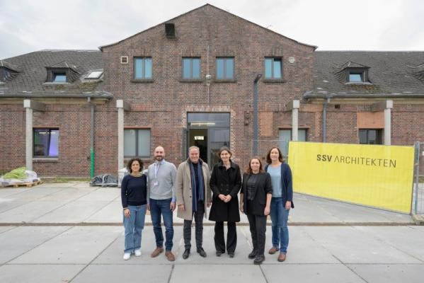 Gaben bei einem Baustellenbesuch gemeinsamen einen Einblick in die Räume des neuen Kultur- und Kreativwirtschaftszentrums MARLENE 42 in der Südstadt (von links): Shiva Hamid (Stabsstelle Kultur- und Kreativwirtschaft, Stadt Heidelberg), Philipp Eisele (Heidelberger Dienste), Oberbürgermeister Eckart Würzner, Bürgermeisterin Martina Pfister, Nadine Hülden (Geschäftsführerin Heidelberger Dienste) und Katharina Pelka (Stabsstelle Kultur- und Kreativwirtschaft). (Foto: Rothe) Sechs Menschen vor Ziegelsteingebäude