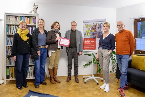 Oberbürgermeister Eckart Würzner (4.v.l.) bei der Übergabe der Weihnachtsspende (v.l.): Doris Fischer Kinder- und Jugendamt, Anja Christiani (Projektkoordination Familienpatenschaften), Stephanie Hoffmann (Leitung Psychologische Beratungsstelle Caritasverband) sowie Carina Krey und Benedikt Widmaier (Familienpaten). (Foto: Rothe) Vier Frauen und zwei Männer stehen in einem hellen Raum, eine Frau hält einen kleinen Scheck in der Hand.