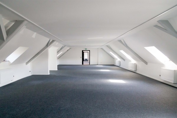 Künftige Mieter und Mieterinnen können sich auf helle und lichtdurchflutete Räume im neuen Kultur- und Kreativzentrum freuen. (Foto: Bormann) Man sieht einen noch leeren Raum mit Dachschrägen des neuen Kultur- und Kreativzentrums MARLENE 42.