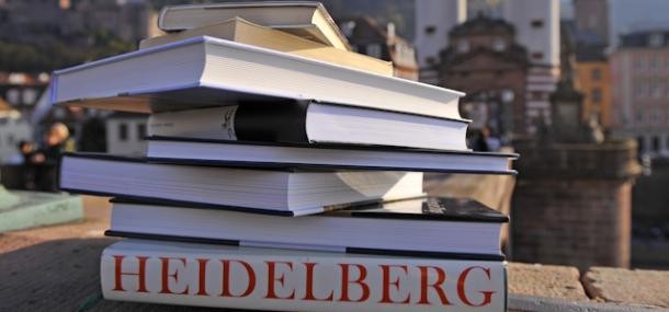 Bücherstapel auf der Schlossmauer vor Stadtansicht Heidelbergs
