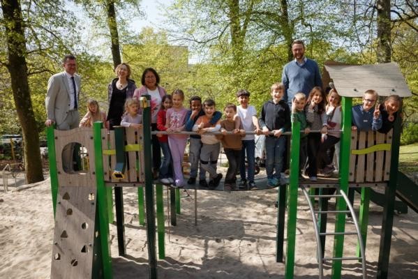 Kinder der Waldparkschule freuen sich mit Umweltbürgermeister Raoul-Schmidt Lamontain (l.), Angelika Kern, Sachgebietsleiterin Spiel- und Freizeitflächen beim Landschafts- und Forstamt (2.v.l.), und den zuständigen Sachbearbeitern Juliah Rais-Morres und Andreas Caelers über den neu gestalteten Spielplatz am Boxbergring-Süd. (Foto: Stadt Heidelberg) Eine Gruppe von Erwachsenen und Kindern auf einem Spiel- und Klettergerüst.
