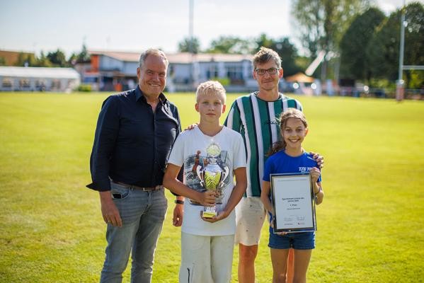 Oberbürgermeister Eckart Würzner (l.) gratulierte Vertreterinnen und Vertretern des Bunsen-Gymnasiums für den Titel „Sportlichste Schule“. (Foto: Dittmer) Ein Schüler und eine Schülerin und zwei Herren posieren auf einem Sportfeld.