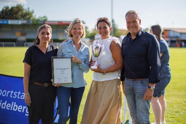 Sportlichste Grundschule wurde die Kurpfalzschule – Oberbürgermeister Eckart Würzner (l.) gratulierte den engagierten Lehrkräften. (Foto: Dittmer) Drei Damen und ein Herr posieren auf einem Sportfeld.