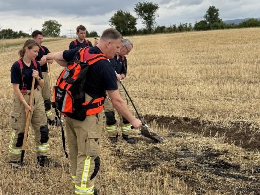 Ein Feuerwehrmann betätigt eine Handspritze seines Wasserrucksacks