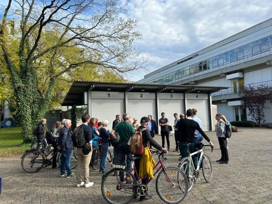 Spaziergang 2024 über den Campus Im Neuenheimer Feld (Foto: Stadt Heidelerg) Viele Menschen stehen draußen vor einem Gebäude