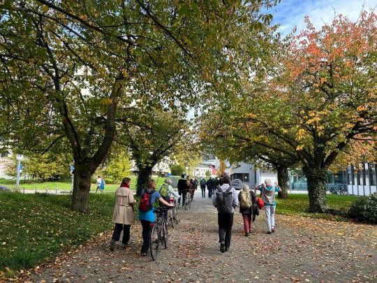 Spaziergang 2024 über den Campus Im Neuenheimer Feld (Foto: Stadt Heidelerg) Menschen laufen zwischen Bäumen