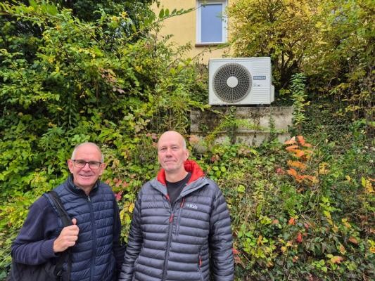 Beim Hausbesuch in Ziegelhausen: Robert Persch (links) vom städtischen Umweltamt und Hauseigentümer Lothar Eisenmann vor der Außenanlage der Wärmepumpe. Eisenmann heizt sein energetisch saniertes Einfamilienhaus seit 2023 mit einer modernen Wärmepumpe. (Foto: Stadt Heidelberg)