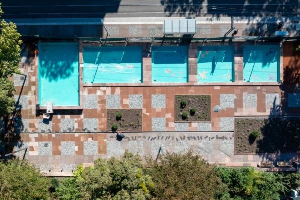 Blick auf die sanierte Grünanlage an der Kurfürsten-Anlage nach Abschluss der Maßnahmen im Oktober 2025. (Foto: Christian Buck) Zu sehen ist die sanierte Brunnenanlage aus der Vogelperspektive. Die Brunnenbecken sind nun gefüllt und kontrastieren in ihrer blauen Farbe mit der parallel verlaufenden Straße.