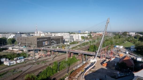 Die Gneisenaubrücke (Foto vom Mai 2025) ist ein wichtiger Bestandteil der geplanten Radwegachse aus der Bahnstadt. Die Brücke soll Ende 2025 fertiggestellt werde und perspektivisch zusammen mit der in Planung befindlichen Brücke über den Neckar eine wichtige Radachse in Nord-Süd-Richtung schaffen. (Foto: Stadt Heidelberg) Zu sehen ist die im Bau stehende Gneisenaubrücke, welche die Zuggleise auf Höhe des Luxor Filmpalasts Kinos überqueert