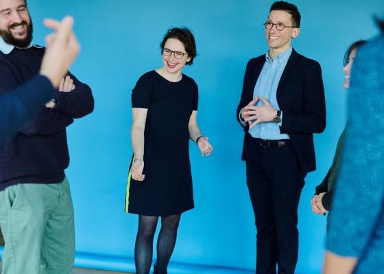 Als Gründerin und Gründer von Mighty Real, einem Beratungsunternehmen für interaktive Veranstal-tungsformate, Team- und Führungskräftetrainings sowie Coachings, unterstützen Elena und Martin R. Lichtenthaler Menschen dabei, schnell in echten Kontakt zu kommen, mutig zusammenzuarbeiten und gelassener mit Komplexität umzugehen. Mehrere Personen lachen.