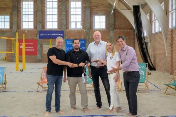 Die neue Beachhalle auf dem Hospital-Areal ist eröffnet: Schlüsselübergabe (von links) mit Oberbürgermeister Eckart Würzner, Architekt Florian Raimund (AAg Architekten), den Vorsitzenden des Beachvereins Heidelberg Bernhard Behler und Vera Cornelius, und Erstem Bürgermeister Jürgen Odszuck. (Foto: Philipp Rothe) Oberbürgermeister Eckart Würzner, Florian Raimund, Bernhard Behler, Vera Cornelius und Jürgen Odszuck bei der Schlüsselübergabe in der Beachhalle.