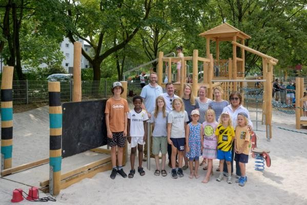 Bürgermeister Raoul Schmidt-Lamontain (hintere Reihe, 2.v.l.) eröffnete den sanierten Kinderspielplatz Baden-Badener Straße im Hasenleiser gemeinsam mit Kindern sowie Vertreterinnen und Vertretern der Stadt Heidelberg. In der hinteren Reihe von links – Andreas Caelers (Landschafts- und Forstamt), Astrid Clausen (Inklusionsbeauftragte), Barbara Pfeiffer (Kinderbeauftragte Rohrbach), Angelika Kern und Juliah Rais-Morres (beide Landschafts- und Forstamt). (Foto Philipp Rothe) Kinder und Erwachsene stehen vor neuen Spielgeräten.