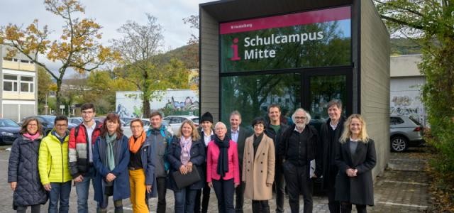 Gruppenbild mit Erster Bürgermeister Jürgen Odszuck, vor dem Holz-Pavillon Schulcampus Mitte.