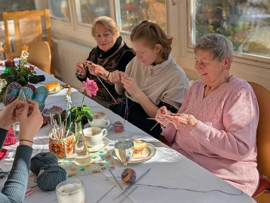 Gemeinsam für den Weltrekord-Stricken: Drei Heidelberger Seniorenzentren bieten jetzt offene Strickcafés für Menschen aller Generationen an. (Foto: Stadt Heidelberg) Drei Personen, die stricken.