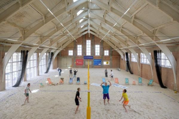Das Hochbauamt der Stadt Heidelberg hat die 46 mal 21 Meter große Halle saniert, deren Dach an einen umgedrehten Schiffskörper erinnert. Neben drei Spielfeldern entstanden Umkleiden, Sanitärbereiche und Flächen für Vereins- und Techniknutzungen. (Foto: Philipp Rothe) Beachvolleyball-Spielende in der Beachhalle.