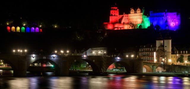 Blick auf das Schloss Heidelberg, dass in Regenbogenfarben angestrahlt wird.