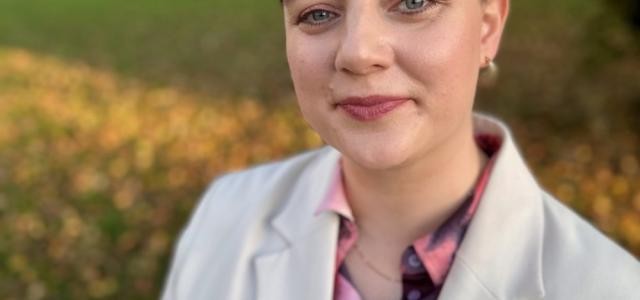 Portraitbild von Sandra Arendarczyk vor einer grünen Wiese mit Bäumen