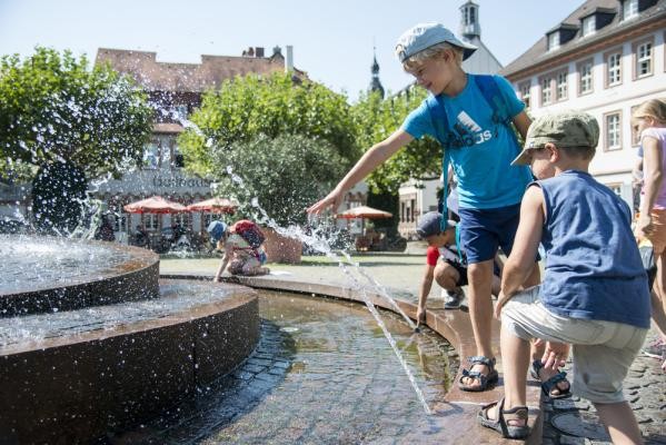 Jetzt reinschauen und Ferien planen: Das Heidelberger Ferienportal bietet fast 400 Angebote von Ostern bis Weihnachten. (Foto: Felix Bäcker) Zwei Jungs, die am Brunnen mit dem Wasser spielen.