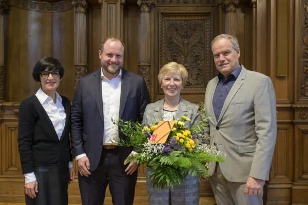 Bei der Verabschiedung im Großen Rathaussaal: Sozialamtsleiterin Angelika Haas-Scheuermann (2. von rechts) mit Oberbürgermeister Eckart Würzner (rechts), Bürgermeisterin Stefanie Jansen und dem neuen Leiter des Amtes für Soziales und Senioren, Carl Philipp Schöpe. (Foto: Philipp Rothe) Vier Persone (Bürgermeisterin Stefanie Jansen, neuer Leiter des Amtes für Soziales und Senioren, Carl Philipp Schöpe, Sozialamtsleiterin Angelika Haas-Scheuermann mit Blumenstrauß in der Hand und Oberbürgermeister Eckart Würzner.