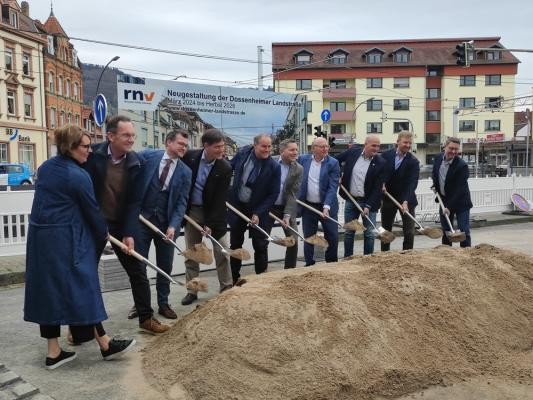 Spatenstich für die Neugestaltung der Dossenheimer Landstraße. (Foto: Stadt Heidelberg) Eine Gruppe von Menschen hält Spaten in den Händen und schaufelt damit an einem Sandhügel.