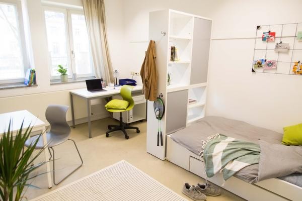 So sieht ein Beispielzimmer im Ausbildungshaus II aus. (Foto: Bormann) Blick in ein Zimmer mit Schreibtisch, Trennregal und Bett.