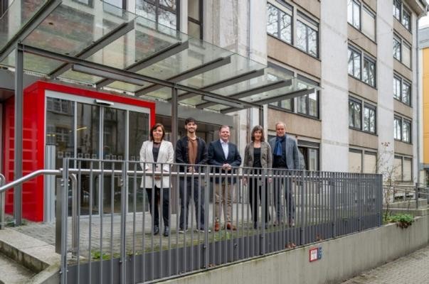 Vor dem neuen Wohnheim (von links): Nadine Hülden (Geschäftsführerin Heidelberger Dienste), Bewohner Guilherme Pereira Ferreira, Jörg Wegener (Geschäftsführer Schmieder Kliniken), Heidi Farrenkopf (Geschäftsführerin Altenhilfe der Evangelischen Stadtmission) und Oberbürgermeister Eckart Würzner. (Foto: Tobias Dittmer) Verschiedene Personen stehen mit Oberbürgermeister Eckart Würzner vor neuem Wohnheim