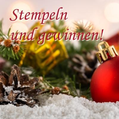 Symbolbild Gewinnspiel Kirchheim. (Foto: Adobe) Auf Kunstschnee liegt Weihnachtsdekoration, darüber steht der Schriftzug "Stempeln und gewinnen!".