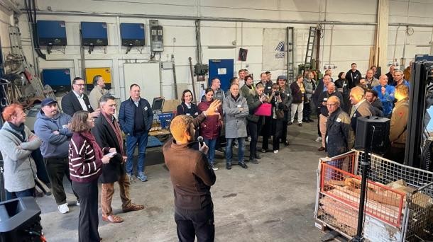 Julius Rieger (M.) erklärte, welche Herausforderungen es für ihn als jungen Gründer gab. (Foto: Stadt Heidelberg) Eine Halle, in der eine Menge Menschen stehen. Einer von ihnen spricht durch ein Mikrofon.
