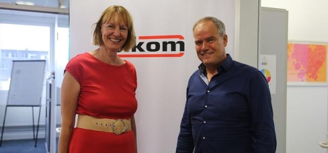 Links Natascha Hoffmeister, rechts Oberbürgermeister Eckart Würzner, im Hintergrund das Logo der Firma Sikom Software GmbH.