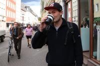 Felix trinkt auf der Hauptstraße aus seinem Kaffeebecher. (Foto: Stadt Heidelberg)