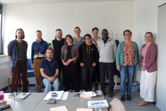 Eine Gruppe Personen posiert in einem Innenraum für ein Foto
