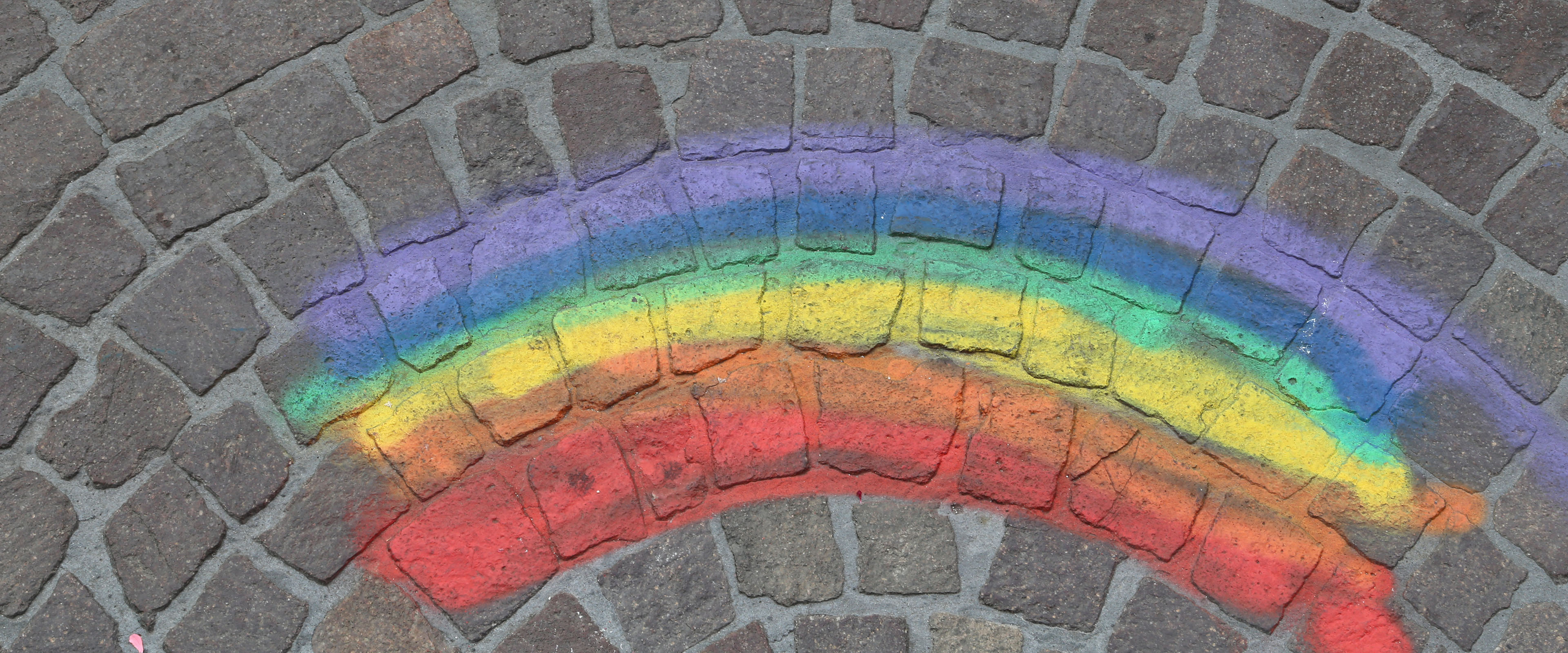 Regenbogen mit Kreide auf Pflastersteinen