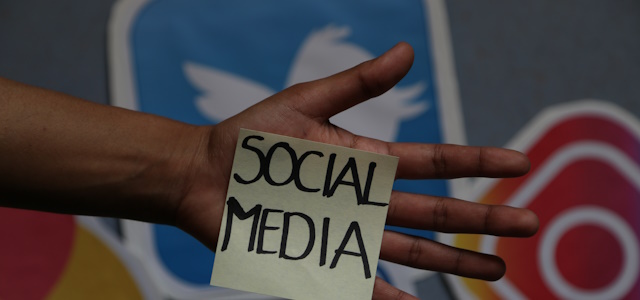 Symbolbild Social-Media (Foto: Stadt HD) Eine ausgestreckte Hand mit einem Post It, auf dem in Großbuchstaben Social Media steht. Im Hintergrund sind die Icons von Instagram und Twitter zu sehen.