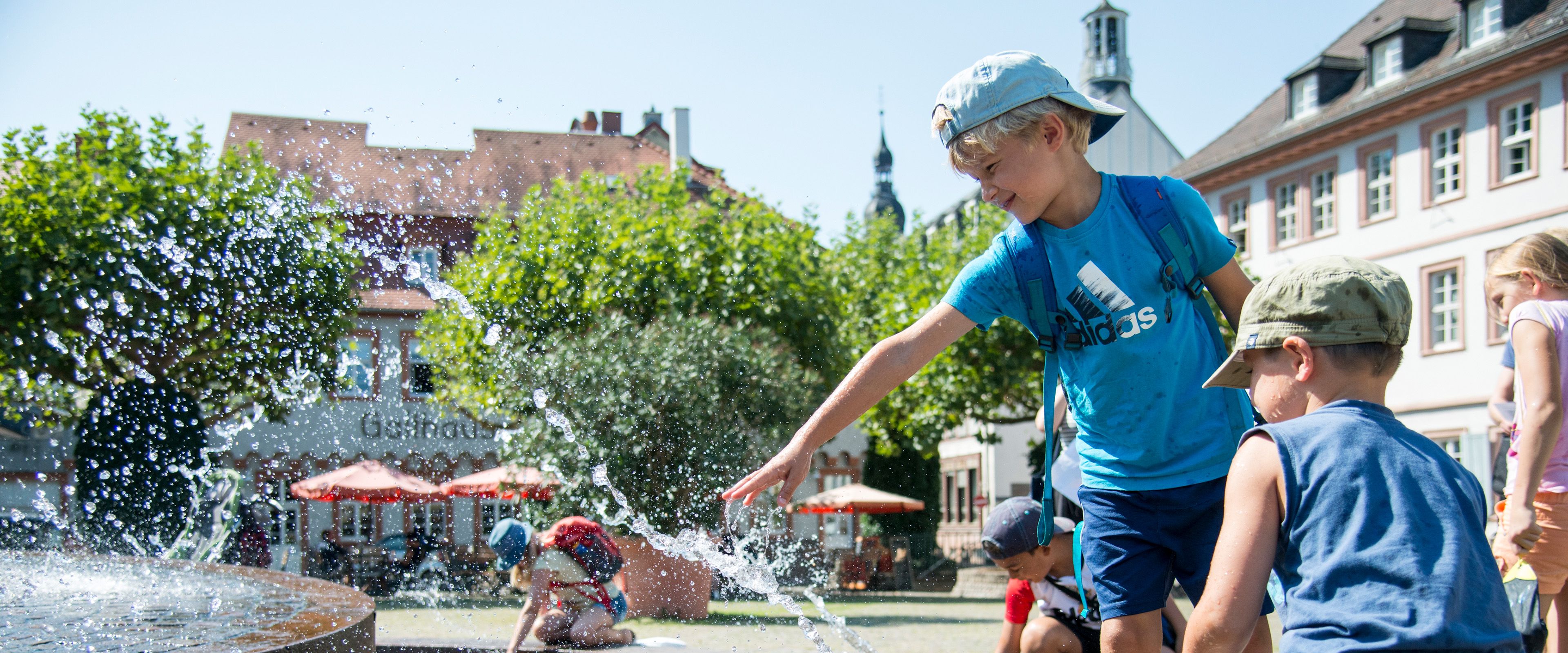 KInder spielen am Brunnen 